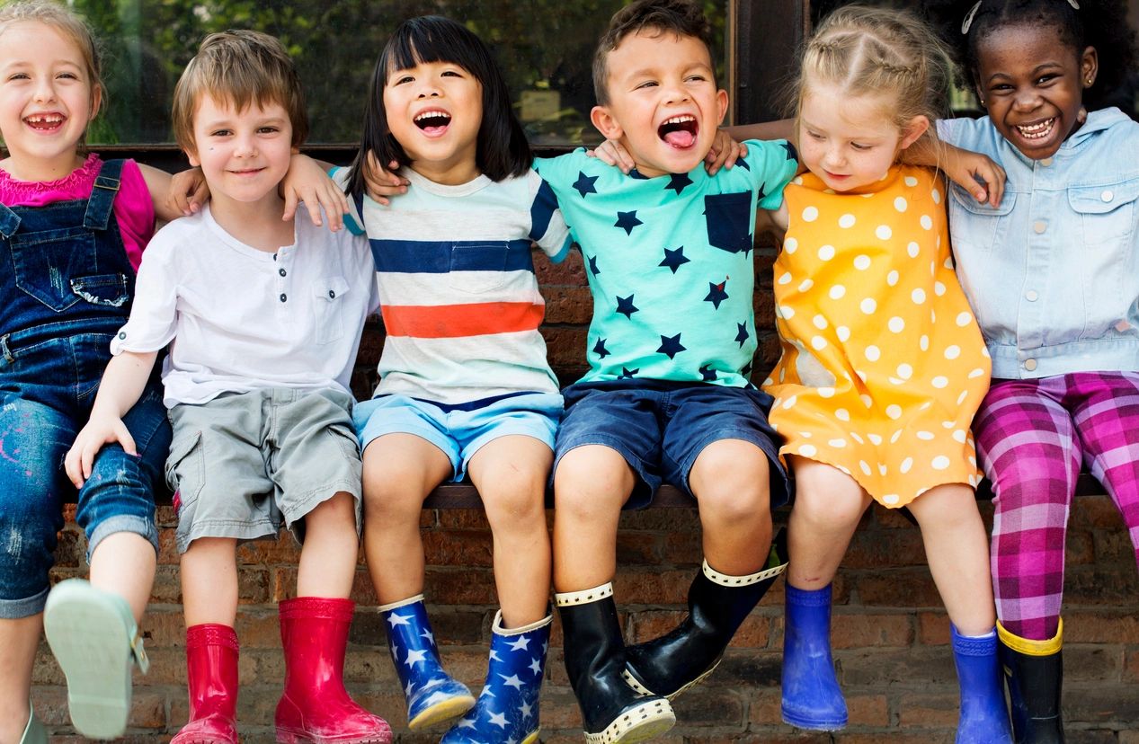 A group of children sitting on top of a bench.