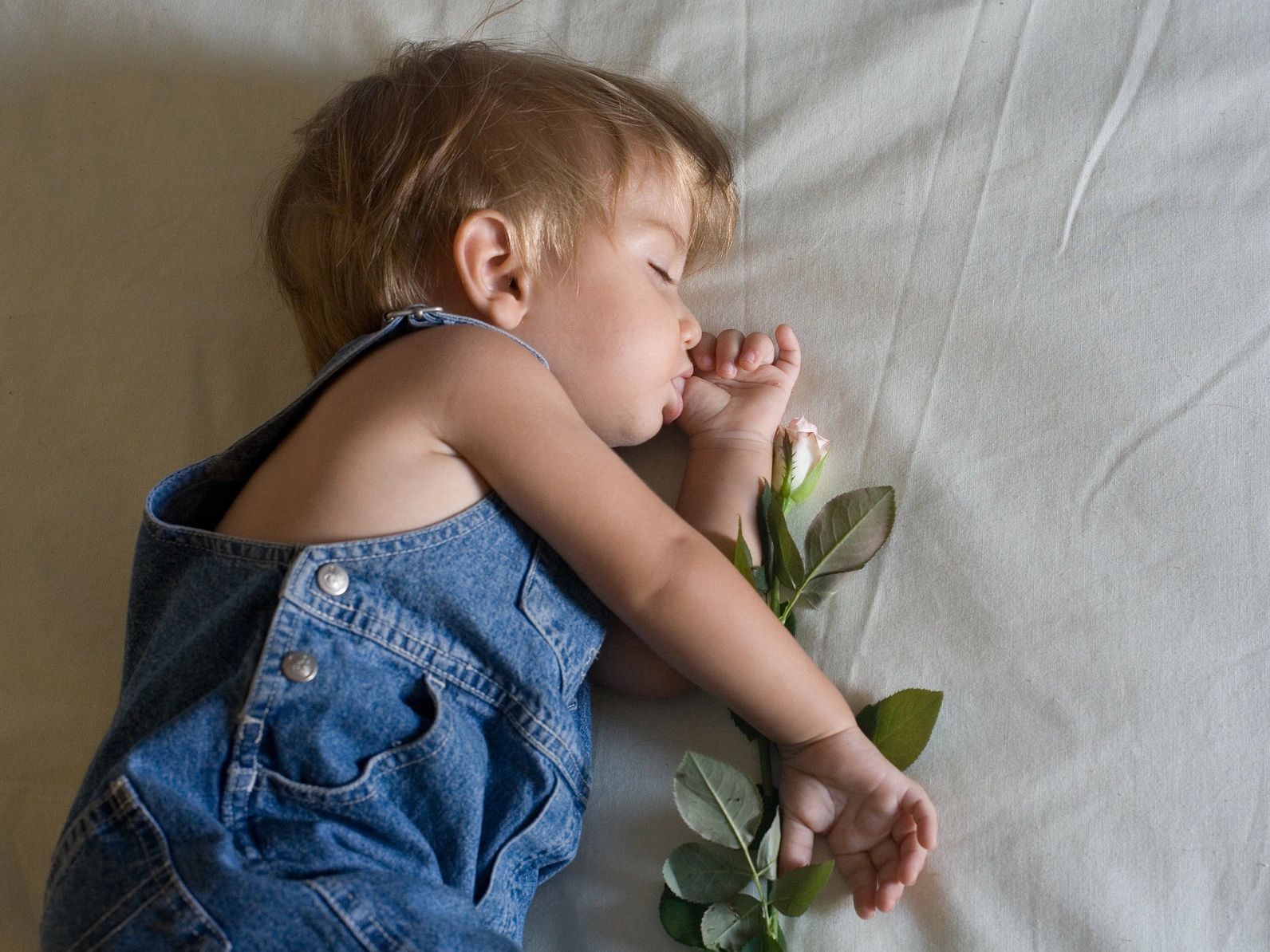 A child sleeping on the bed with flowers