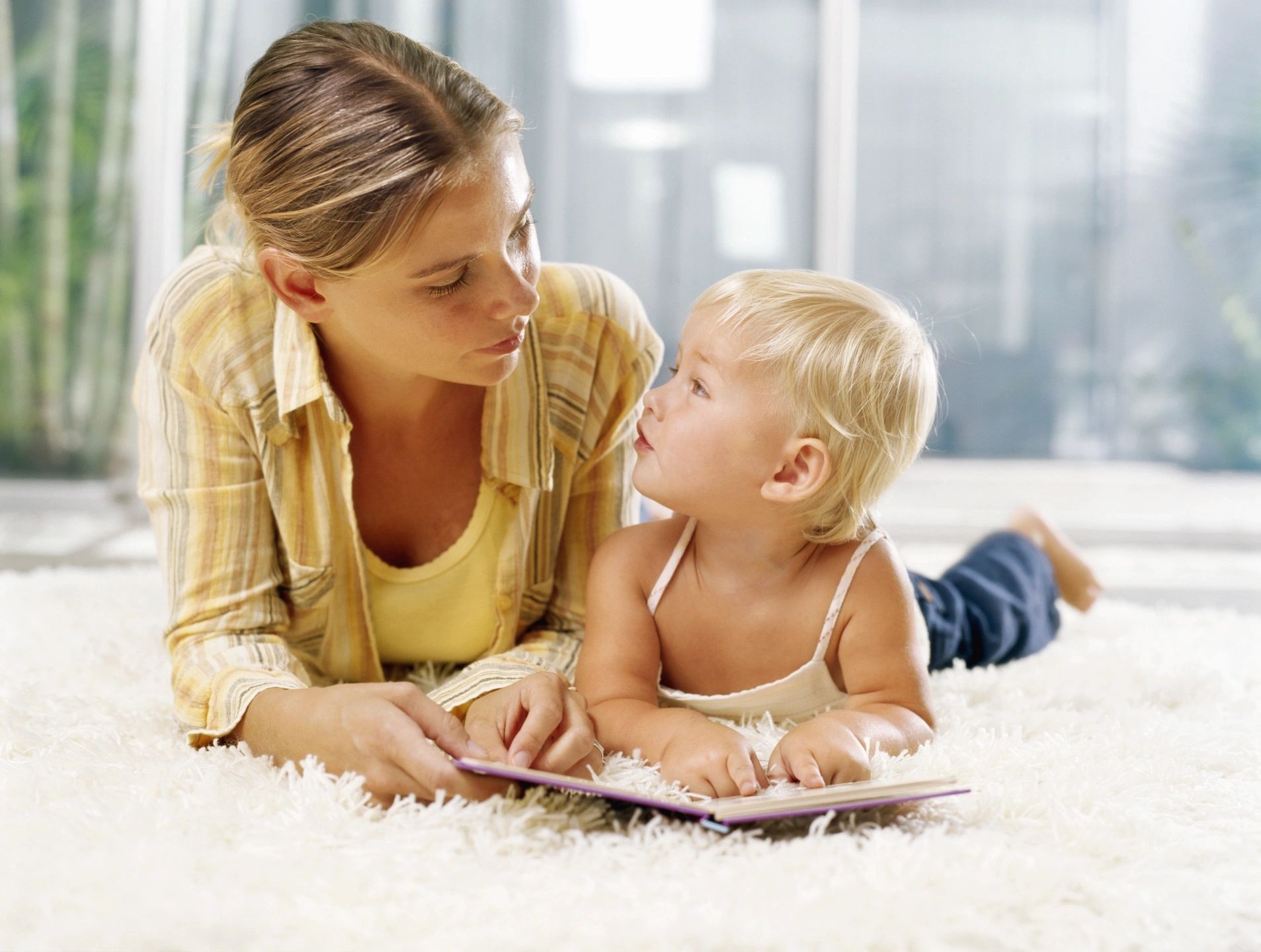 A woman and child laying on the floor