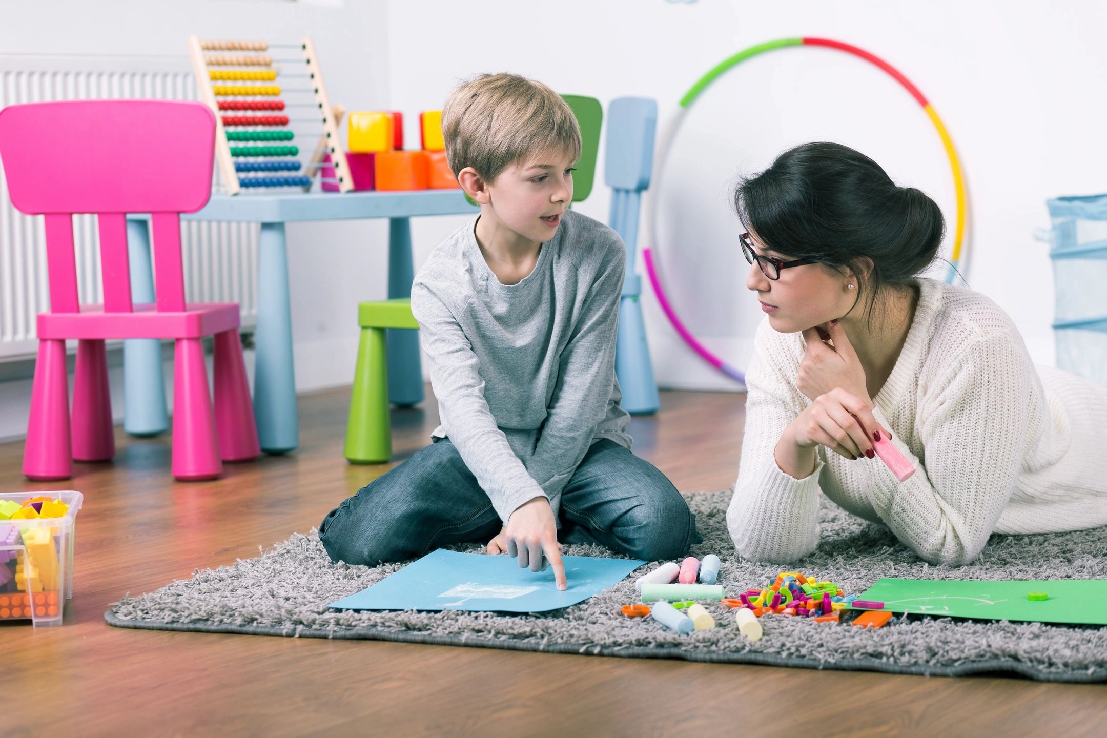 A woman and boy sitting on the floor