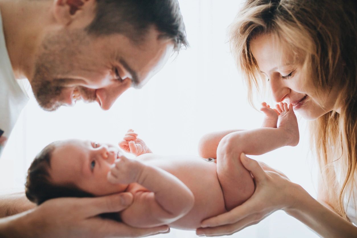 A man and woman holding a baby in their arms.